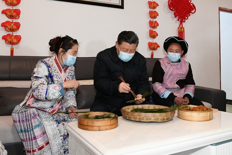2021年2月3日下午，習(xí)近平在貴州畢節(jié)市黔西縣新仁苗族鄉(xiāng)化屋村苗族村民趙玉學(xué)家，同一家人邊聊家常邊制作當(dāng)?shù)貍鹘y(tǒng)節(jié)日食品黃粑。新華社記者 李學(xué)仁 攝