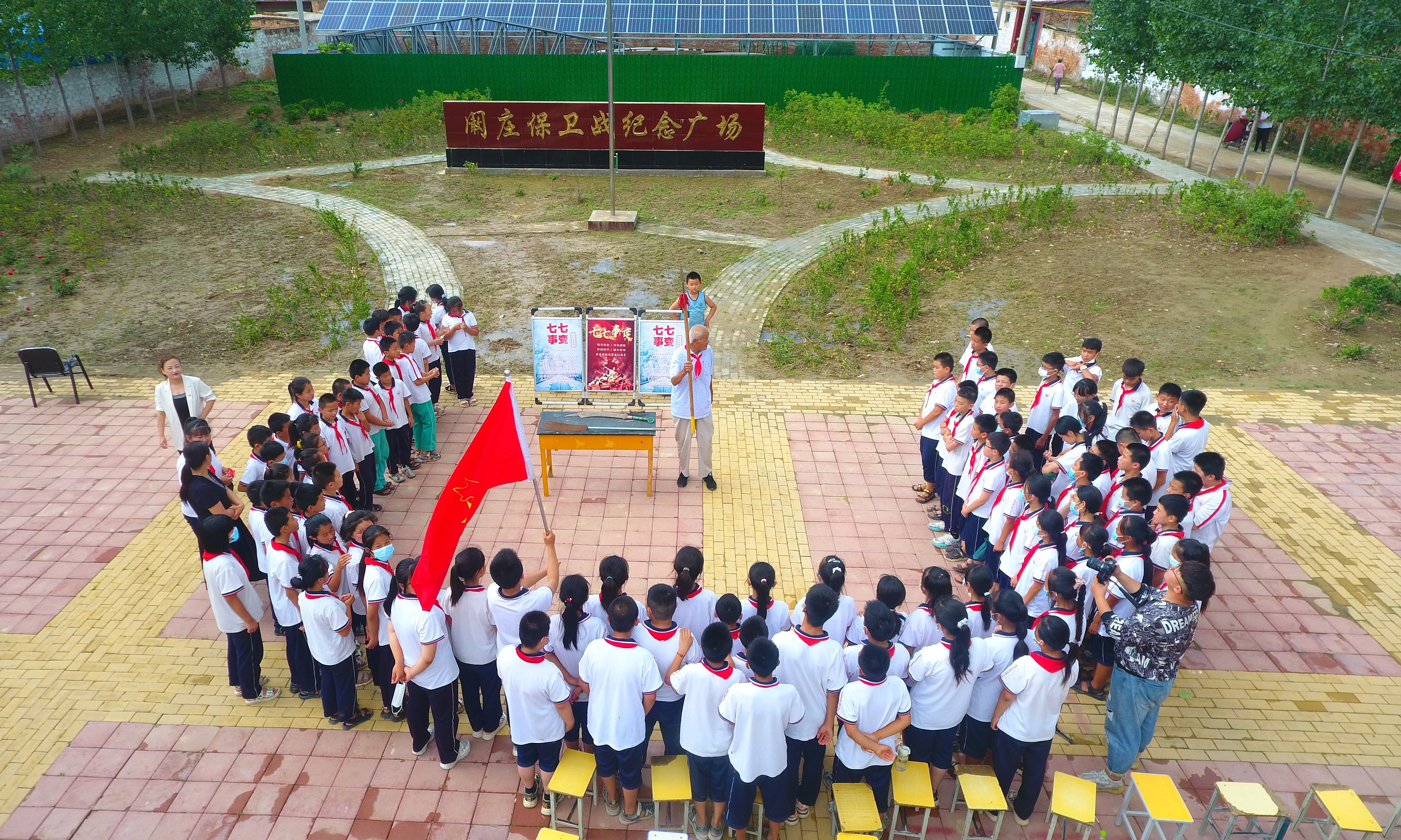 2022年7月6日，山東省聊城市，在茌平區(qū)菜屯鎮(zhèn)闞莊村的闞莊保衛(wèi)戰(zhàn)紀(jì)念廣場(chǎng)，闞莊保衛(wèi)戰(zhàn)親歷者王光木老人，為小學(xué)生們講述抗戰(zhàn)故事，展示大刀、長(zhǎng)矛。