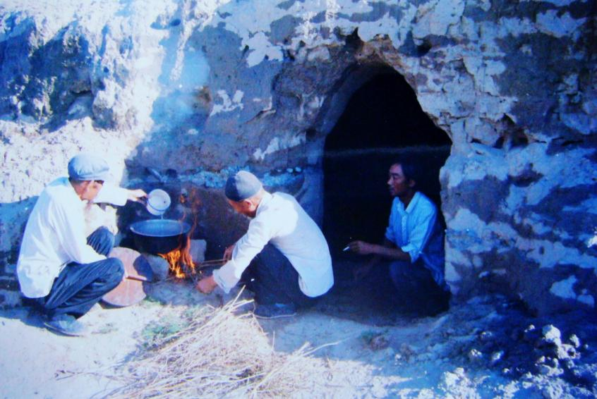1983年，“六老漢”一代治沙人在“地窩子”生活做飯。新華社發(fā)（八步沙林場供圖）